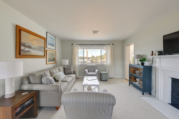 A living room with a sofa, armchair, coffee table, and fireplace. - Waterfront Lancaster House w/ Grill & Dock Access! (Lancaster)