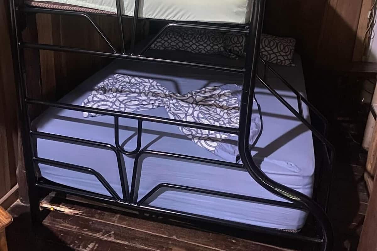 Un lit superposé avec une structure en métal et un matelas à motifs.