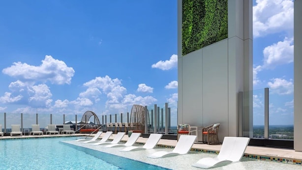 A rooftop pool with white lounge chairs and a view of the ocean. - 1BD/Atlanta - Downtown w/Rooftop Pool and Pool Bar! (Atlanta)