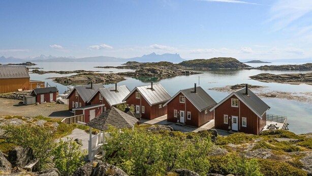 A coastal village with traditional wooden houses, a wooden pier, and a rocky shoreline. - Beautiful home in Offersøy with kitchen (Offersøy)