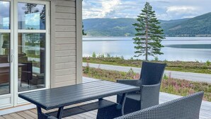 A deck with a table and chairs overlooking a lake and mountains. - Lovely home in Treungen (Treungen)
