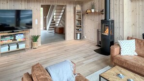 A wooden interior with a TV, sofa, coffee table, and a fireplace. - Lovely home in Treungen (Treungen)