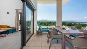 Un balcon doté d’un espace repas, d’un canapé et offrant une vue sur le paysage.