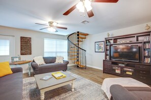 Relax in the spacious living room with a sofa, armchair, and flat-screen TV.