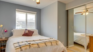 A bedroom with a bed, a bedside table with a lamp, a window, and a sliding door closet. - 12 Mi to Denver: Golden Vacation Rental! (Golden)