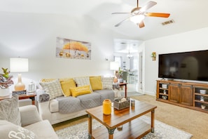 A living room with a sofa, coffee table, and TV stand.