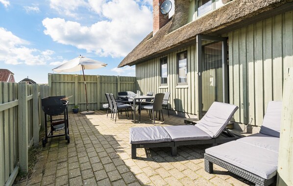 An outdoor patio with a table and chairs, a grill, and lounge chairs. - Awesome home in Harboøre with WiFi (Harboøre)