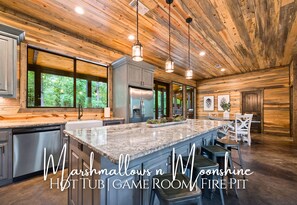 A spacious kitchen with a large island, wooden ceiling, and pendant lighting. - Marshmallows 'n Moonshine | Pet-Friendly Retreat (Broken Bow)