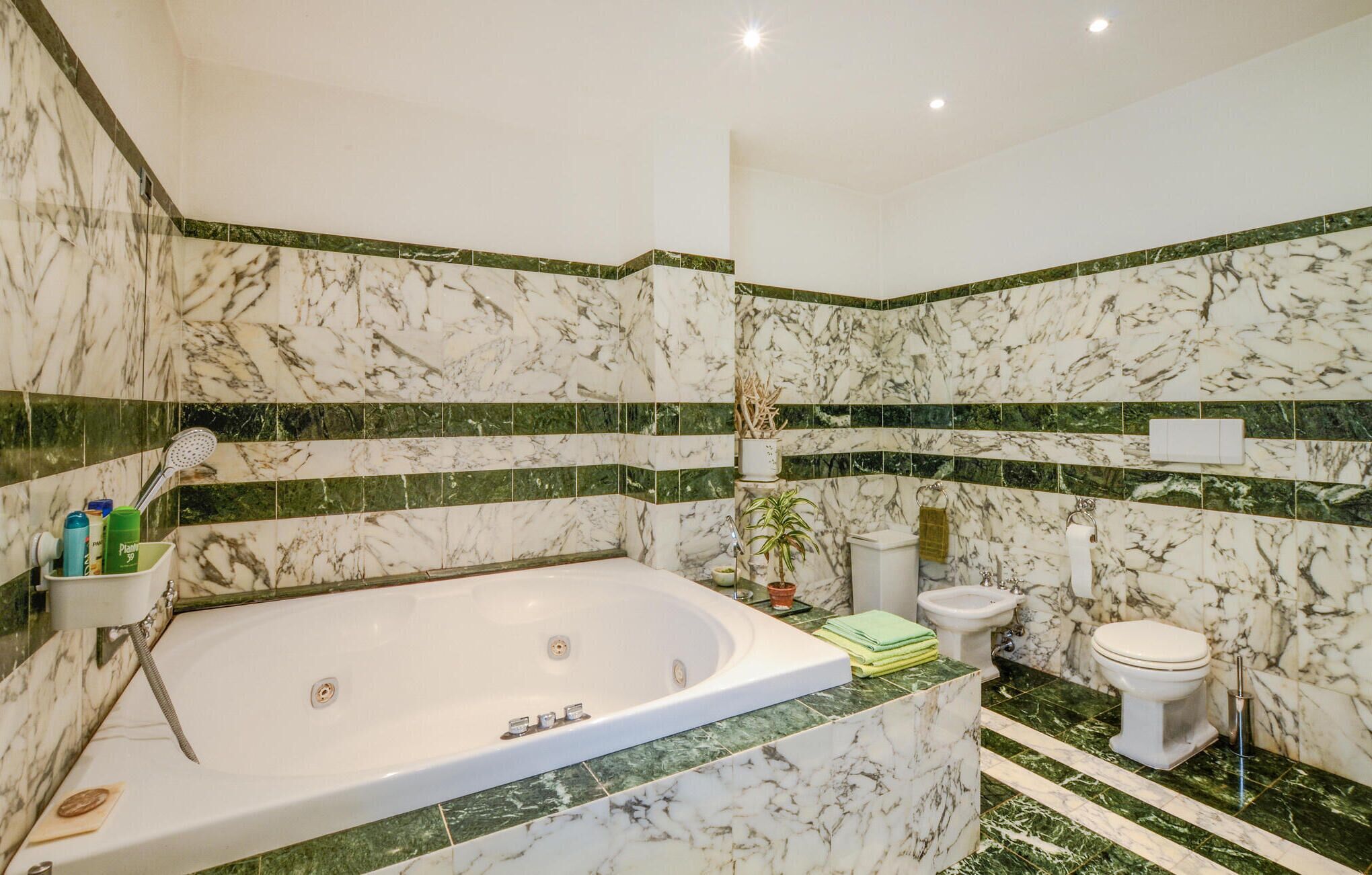 Ein Badezimmer mit Marmorwaschbecken, einer Badewanne, einer Toilette und einem Bidet.