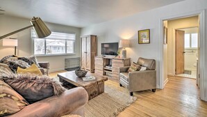 A modern living room with a sofa, coffee table, and TV. There is a wooden cabinet and a lamp. - 1 Mi to Hot Springs! Central Thermopolis Home (Thermopolis)