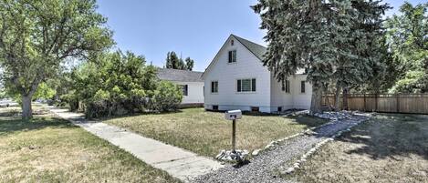A single-story house with a front yard, a mailbox, and a gravel path leading to the house.