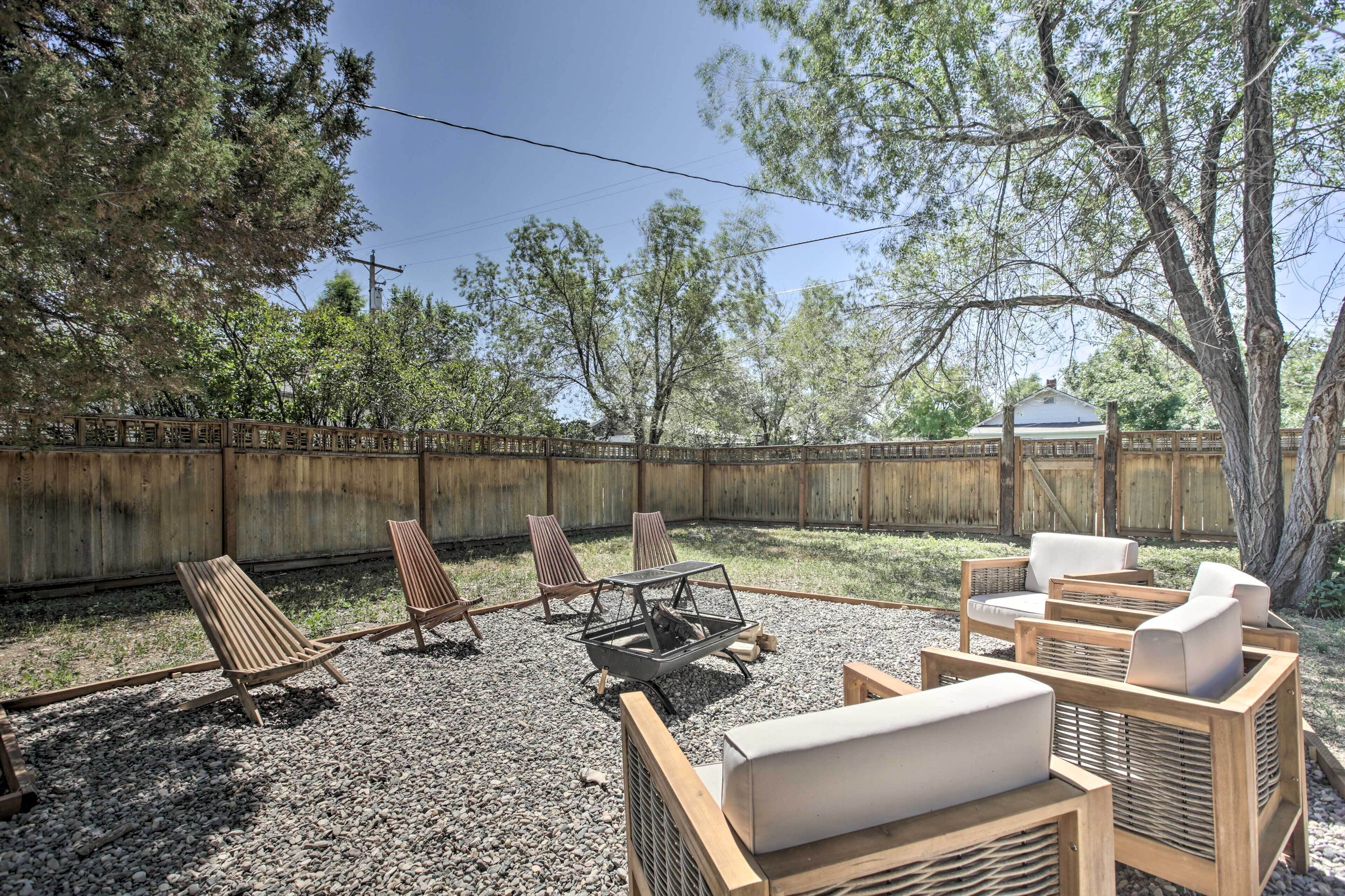 An outdoor seating area with wooden chairs and a fire pit.