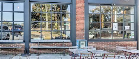 A coffeehouse and bakery with large windows and outdoor seating.