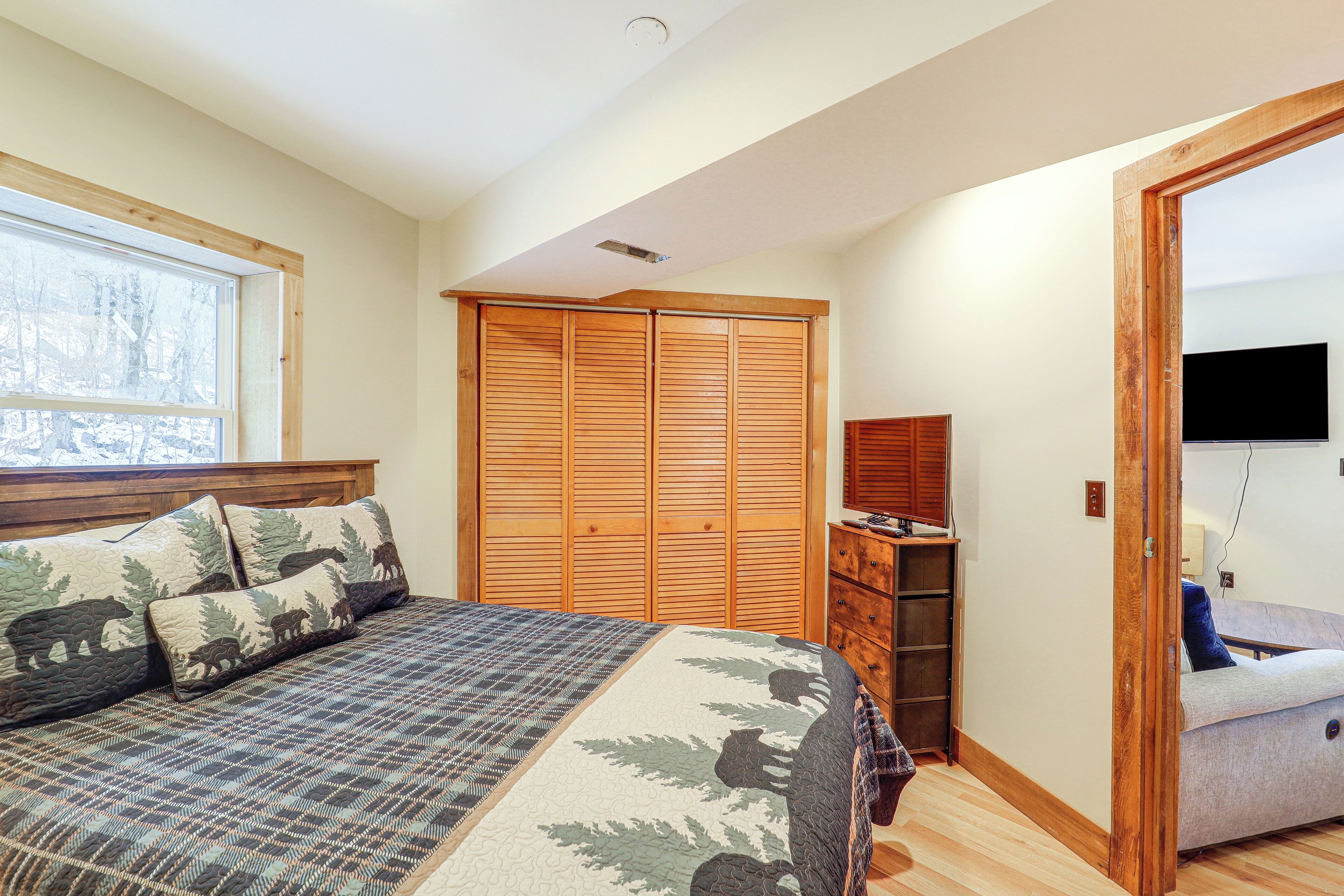 Une chambre à coucher comprenant un lit, une armoire, une commode et un téléviseur.