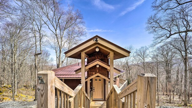 A wooden cabin with a porch and a door, surrounded by trees. - Beech Mountain Cabin w/ Deck: Half-mi to Skiing (Banner Elk)