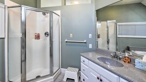 A bathroom with a glass shower enclosure, a vanity with a sink, and a large mirror. - Deck + Fire Pit: Waterfront Lake Michigan Escape (Algoma)