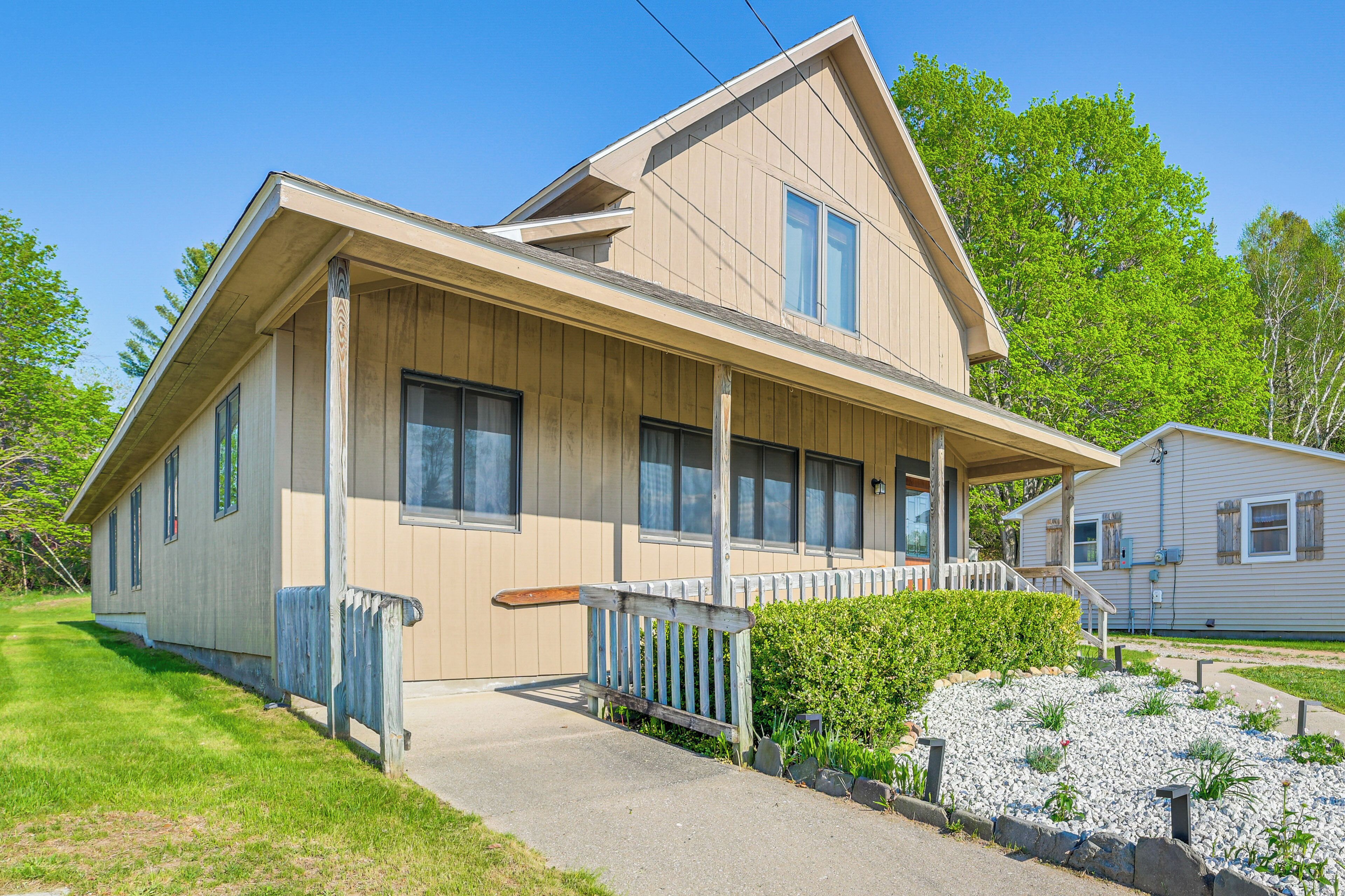 A two-story house with a front porch, a small attached garage, and a well-maintained lawn.