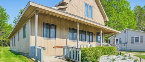 A two-story house with a front porch, a small attached garage, and a well-maintained lawn.