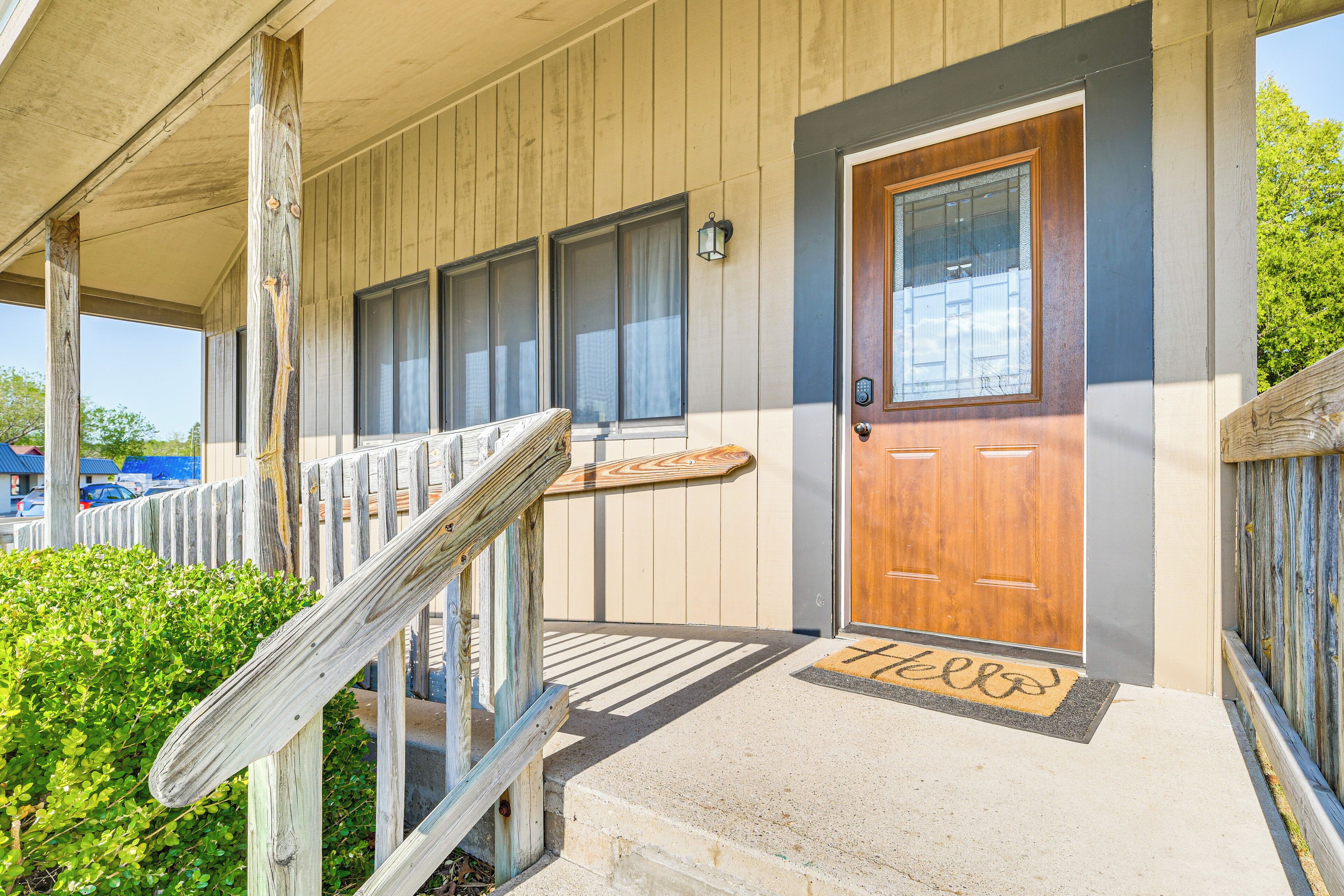 A wooden building with a wooden door, a set of stairs, and a welcome mat.