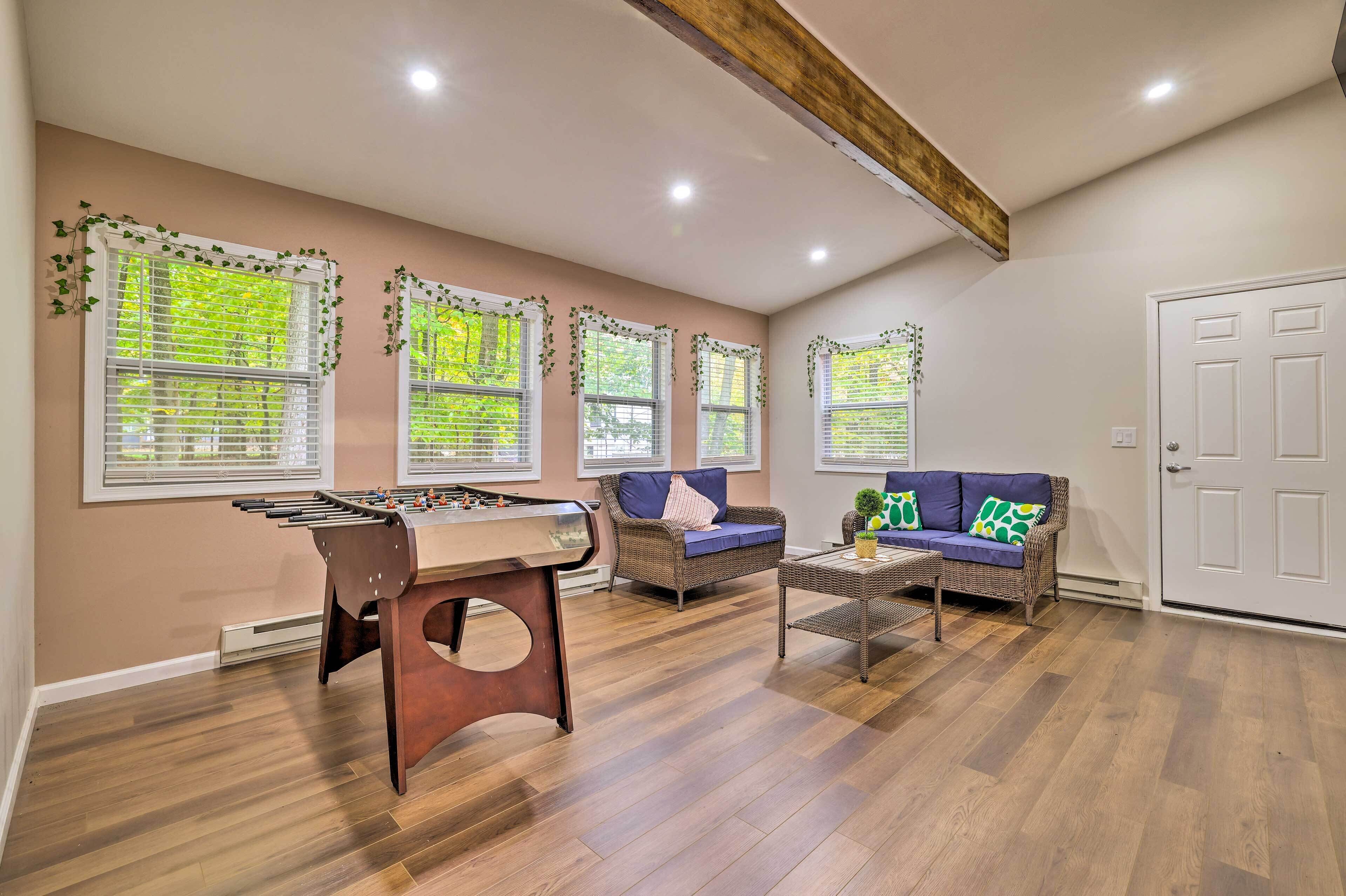 A spacious living room with a foosball table, a sofa, and a coffee table.