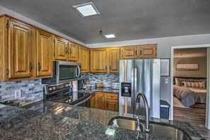 A modern kitchen with wooden cabinets, stainless steel appliances, granite countertops, and a built-in microwave. - Pool Access: Condo w/ Patio in Afton (Afton)