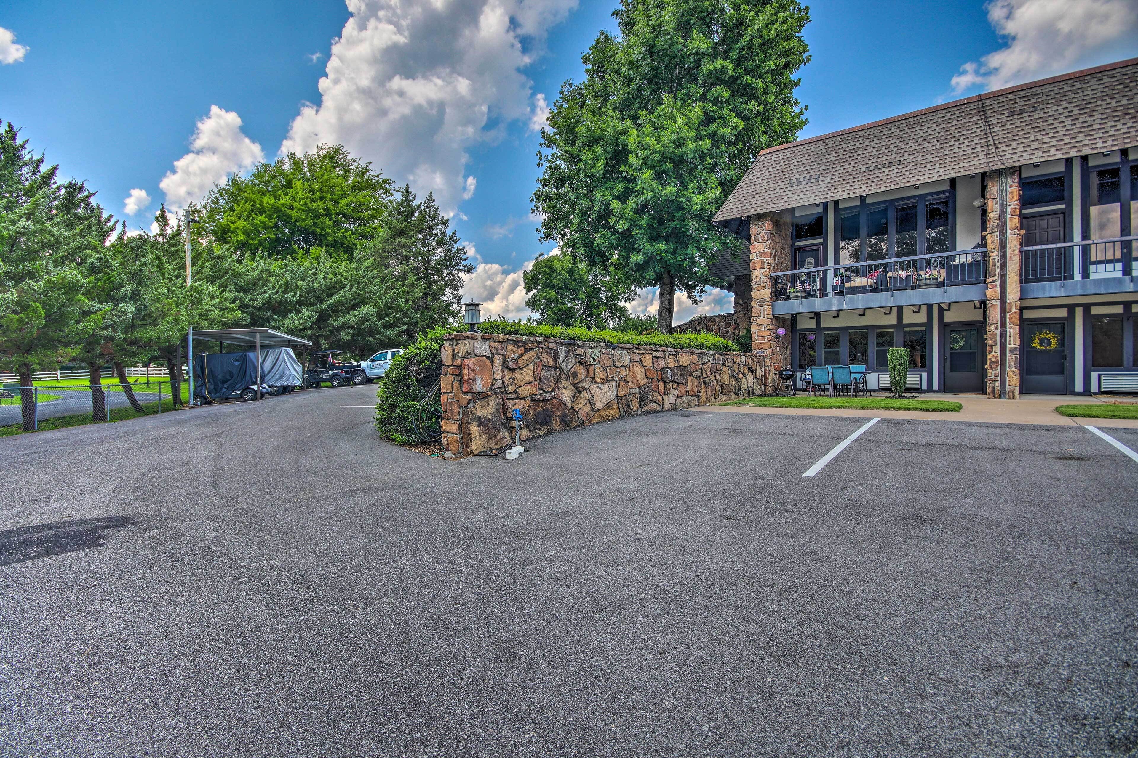 A building with a stone facade, a covered outdoor seating area, and a parking lot.