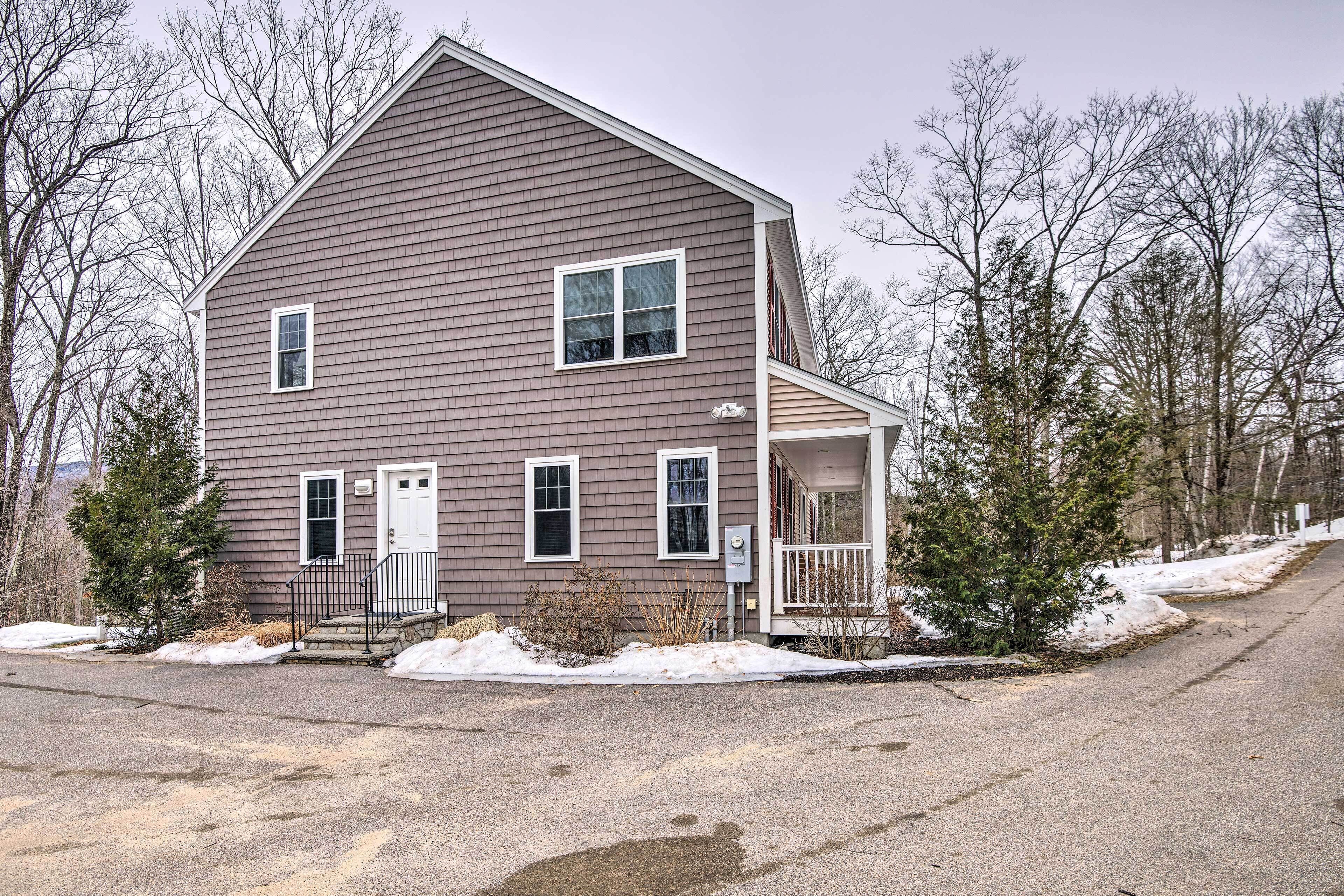 A two-story house with a front porch, a garage, and a driveway.