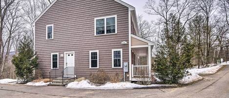 A two-story house with a front porch, a garage, and a driveway.
