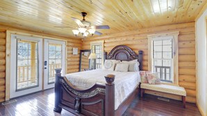 A log cabin bedroom with a wooden bed, a bench, and a ceiling fan. - Large Sterling Cabin < 1 Mi to Palisade State Park (Sterling)