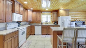 A wooden cabin-style kitchen with wooden cabinets, a white stove, and a sink. - Large Sterling Cabin < 1 Mi to Palisade State Park (Sterling)