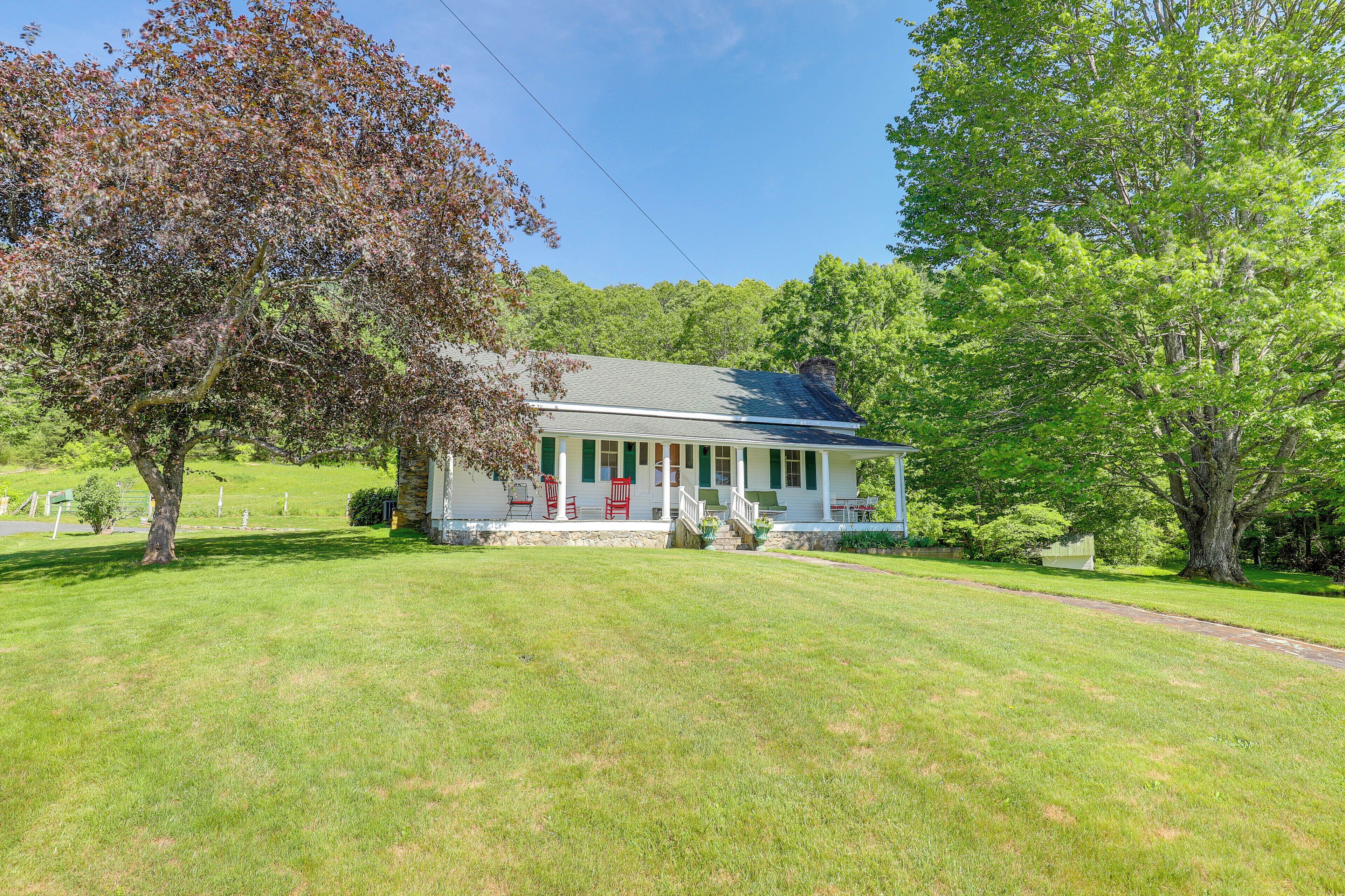 A house with a front porch, a lawn, and trees.