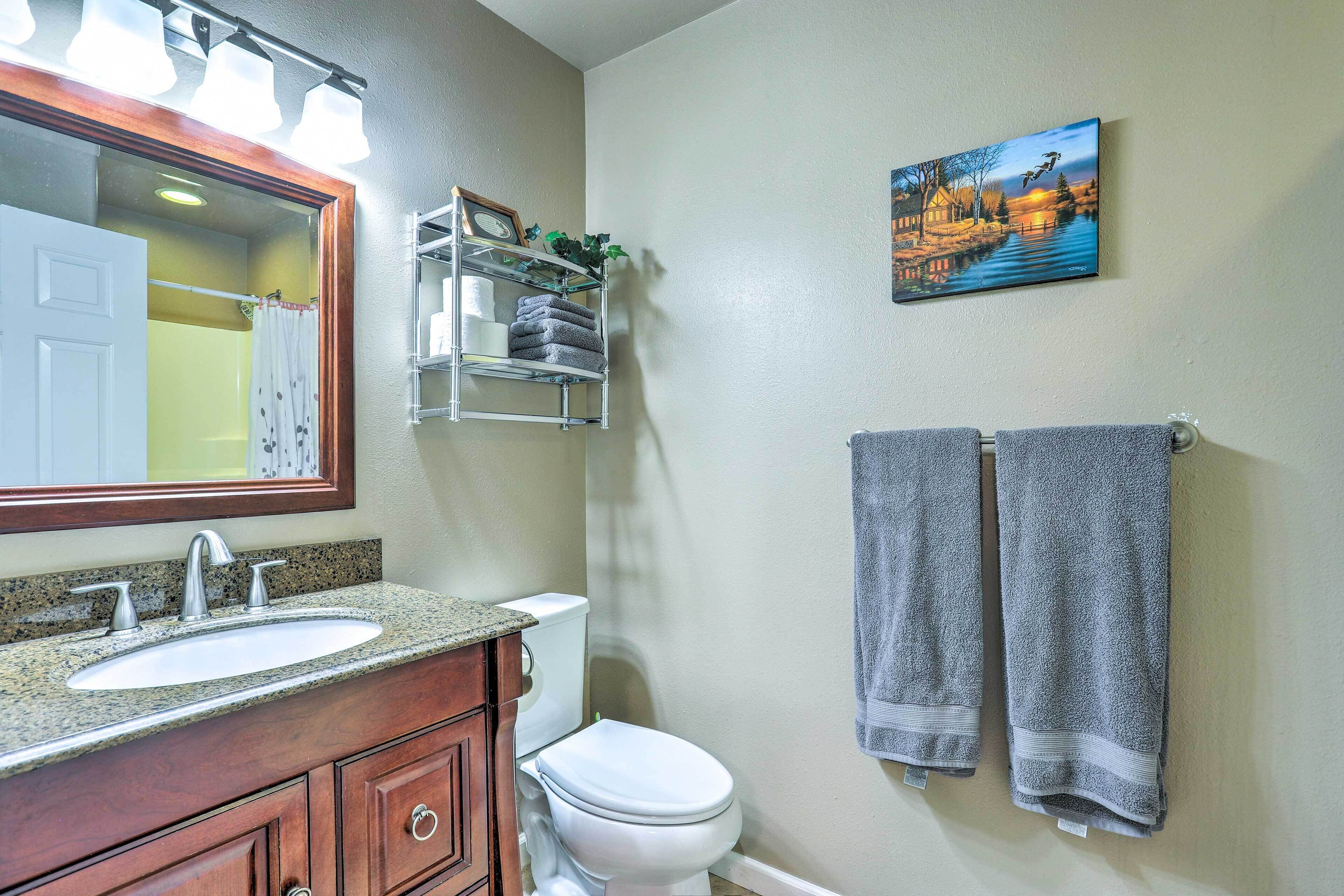 Une salle de bain équipée d’un lavabo, d’un miroir, d’un porte-serviettes et de toilettes.