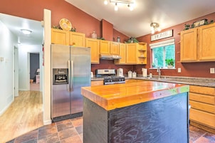 Una cocina moderna con armarios de madera, electrodomésticos de acero inoxidable y una isla grande.