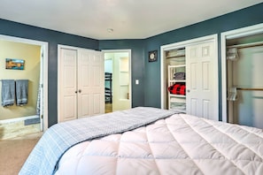 A bedroom with a bed, a closet, and a bathroom visible through an open door. - Charming Wasilla Retreat: Walk to Lake Lalen! (Wasilla)