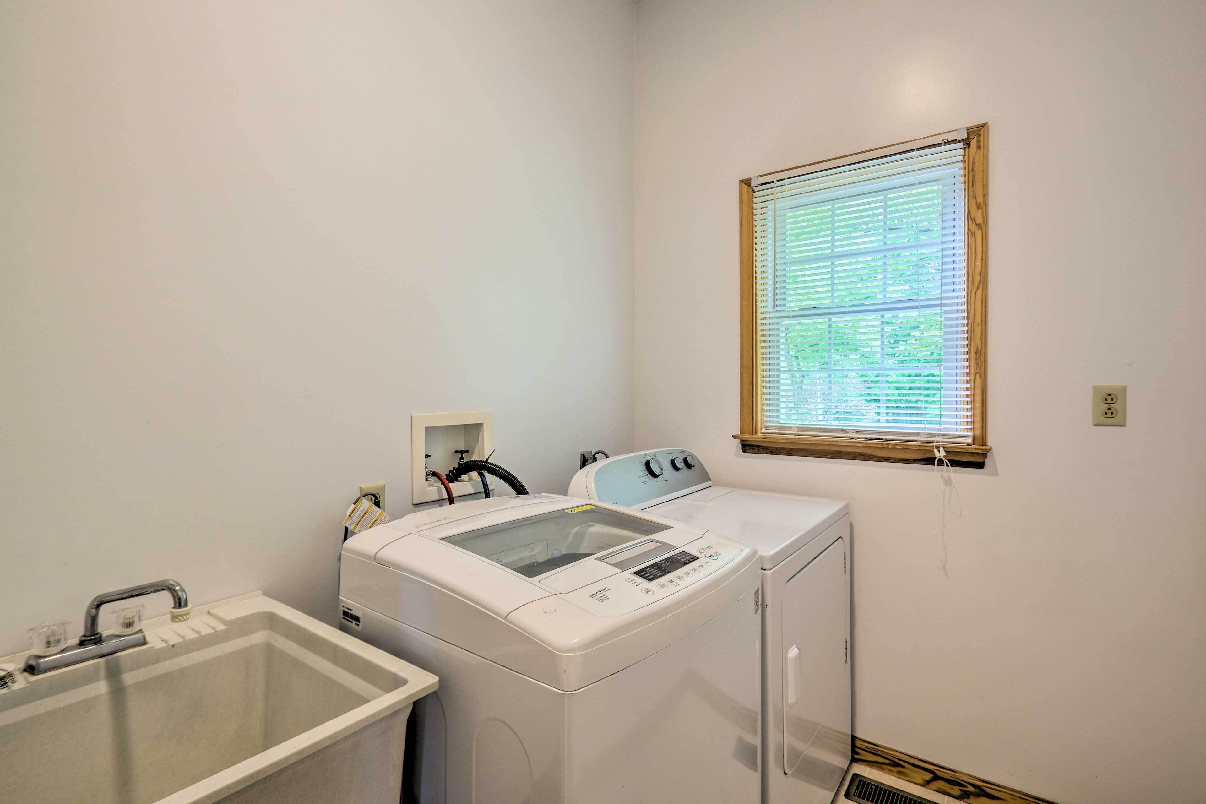 A laundry area with a washing machine, dryer, and sink.