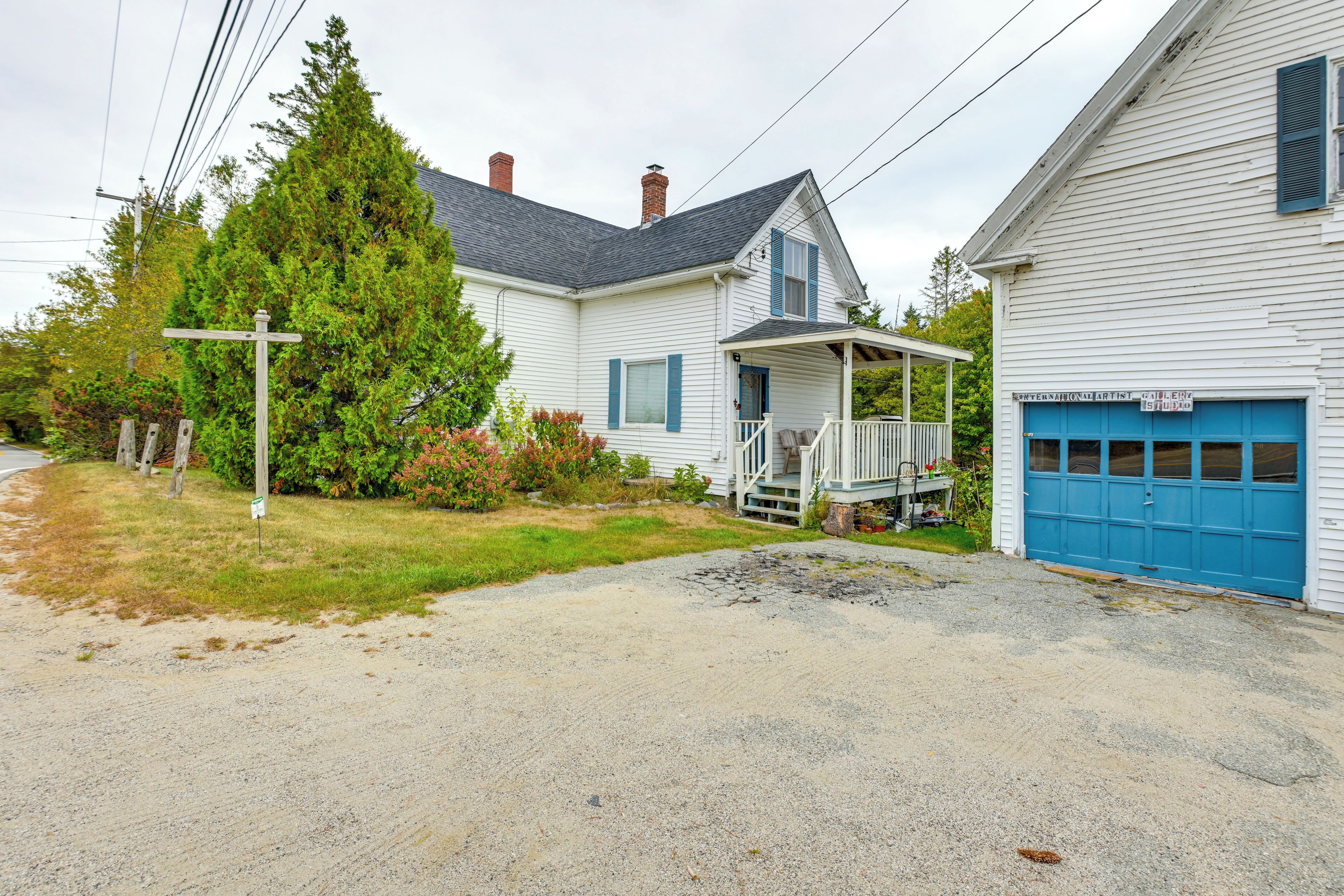 A two-story house with a porch, a garage, and a driveway.