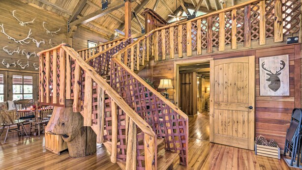 A wooden staircase with a lattice railing leading to a second floor. - Countryside Cabin Retreat w/ Outdoor Kitchen! (Rienzi)