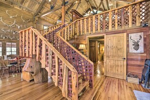 A wooden staircase with a lattice railing leading to a second floor. - Countryside Cabin Retreat w/ Outdoor Kitchen! (Rienzi)