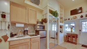 A modern kitchen with wooden cabinets, stainless steel appliances, and a tiled backsplash.
