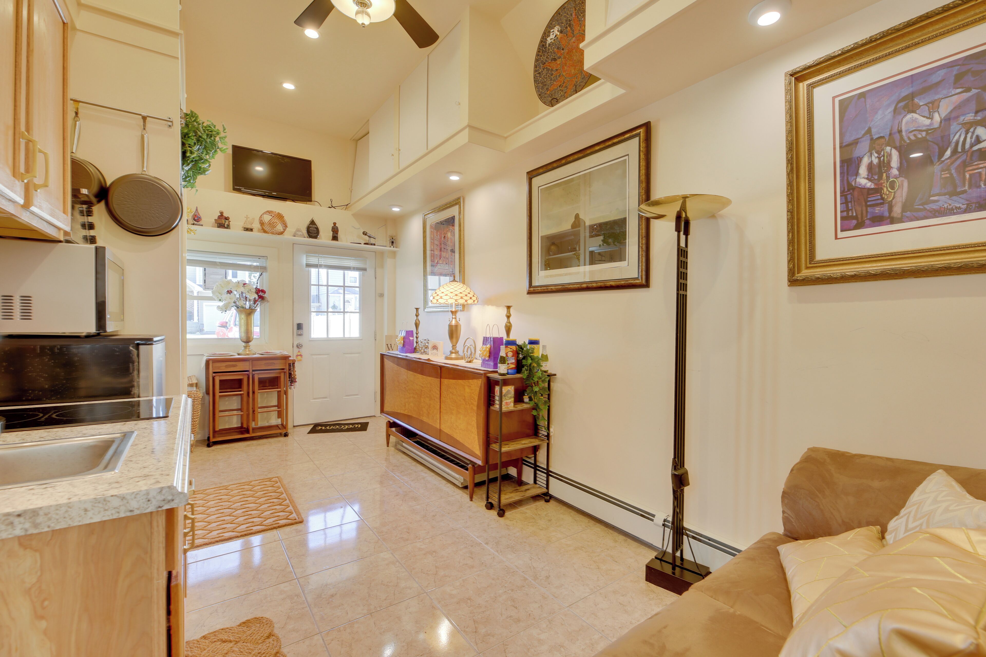 A spacious living area with a large window, a kitchen with modern appliances, and a dining area with a wooden table and chairs.