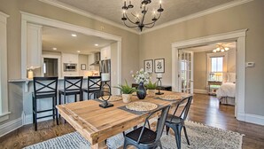 A spacious dining area with a wooden table and chairs, a chandelier, and potted plants. - Countryside Cottage w/ Large Yard Near Topeka (Silver Lake)