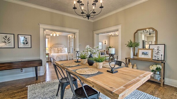 A dining area with a wooden table, chairs, and a chandelier. - Countryside Cottage w/ Large Yard Near Topeka (Silver Lake)