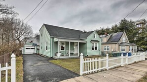 A two-story house with a front porch, a garage, and a white picket fence. - Bridgeport Vacation Rental - Walk to Beach! (Bridgeport)