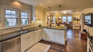 A modern kitchen with white cabinets, a granite countertop, and a built-in dishwasher. - Bridgeport Vacation Rental - Walk to Beach! (Bridgeport)