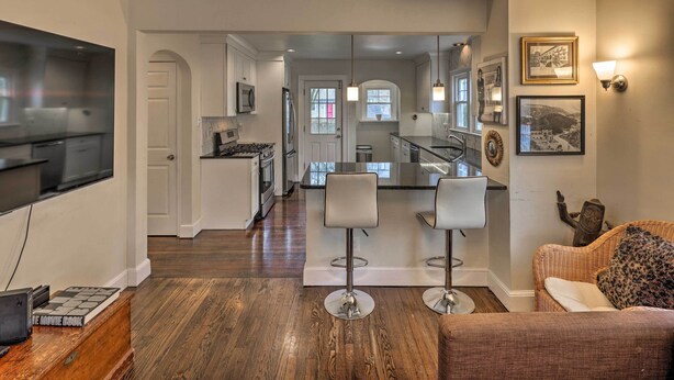 A modern kitchen with a central island, bar stools, and a dining area. - Bridgeport Vacation Rental - Walk to Beach! (Bridgeport)