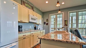 A modern kitchen with white cabinets, a granite countertop, and a built-in microwave. - Blue Ridge Mountain Rental w/ Hot Tub & Gas Grill! (Marshall)