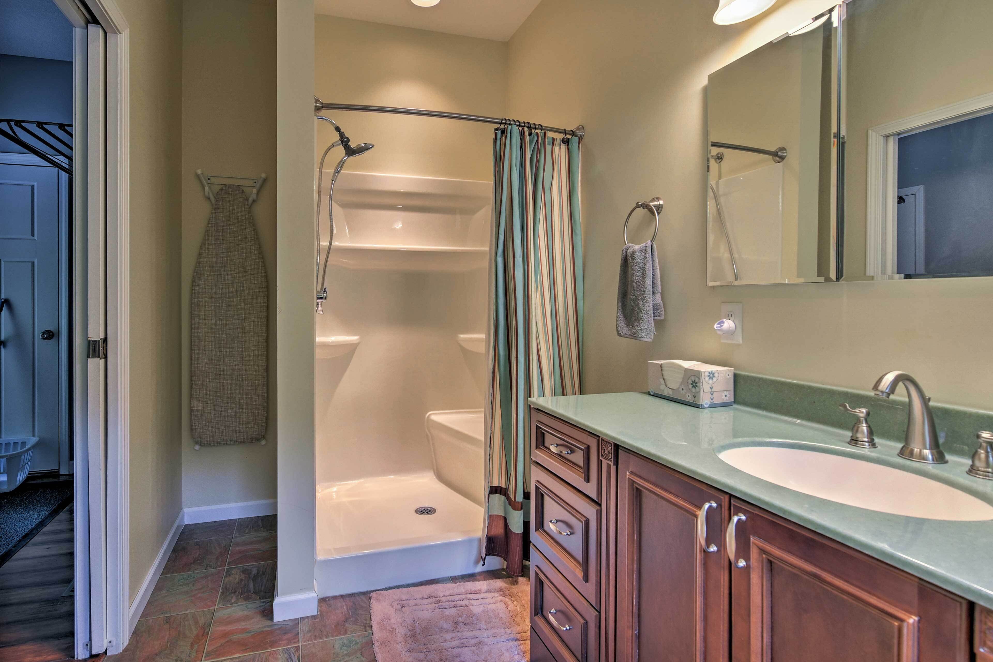 A bathroom with a bathtub, a shower, a sink, and a mirror.