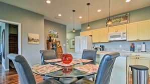 A dining area with a glass table, four chairs, and a red vase centerpiece. - Blue Ridge Mountain Rental w/ Hot Tub & Gas Grill! (Marshall)
