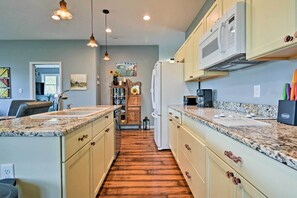 A kitchen with granite countertops, wooden cabinets, and a central island. - Blue Ridge Mountain Rental w/ Hot Tub & Gas Grill! (Marshall)