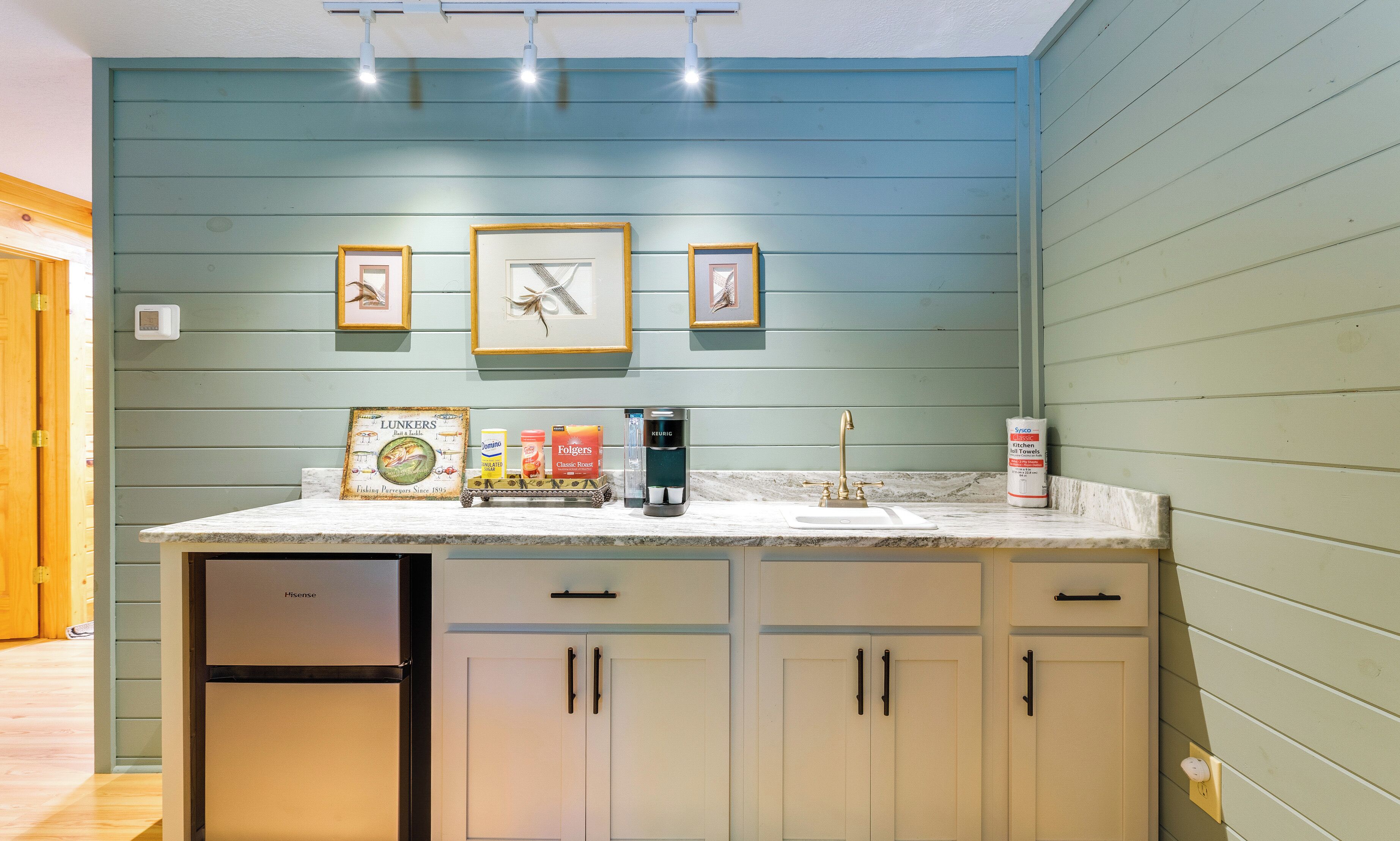 A kitchen with a built-in dishwasher, a coffee maker, and a bottle of kitchen towels.